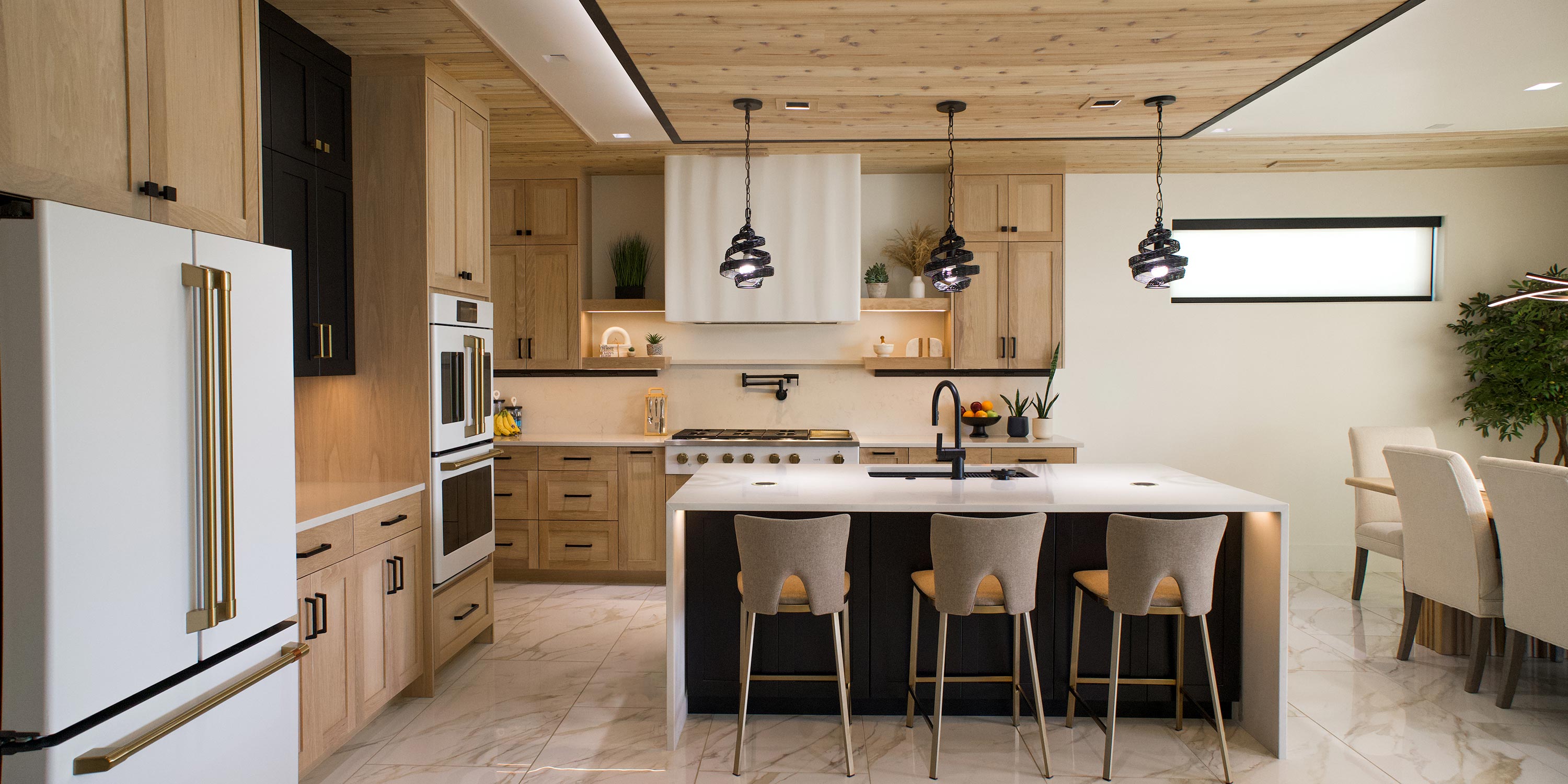 A modern kitchen and dining room with elegant lighting and comfortable seating, integrated with Savant home automation system.