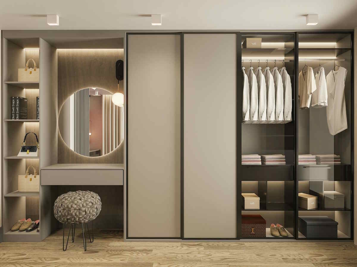 Modern built-in wardrobe system featuring illuminated glass display sections, sliding doors, and an integrated vanity area with a backlit round mirror and textured stool.