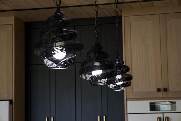 Three spiral-shaped pendant lights hanging over a kitchen island. 