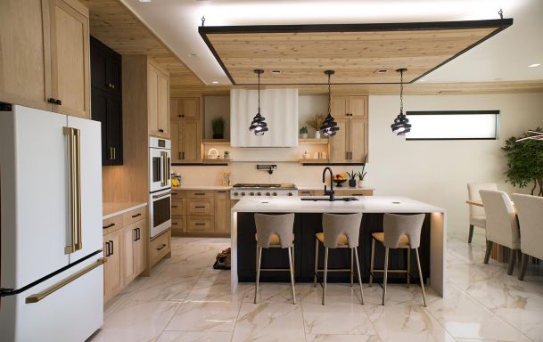 Spacious kitchen with a large island, bar stools, and modern lighting fixtures. 