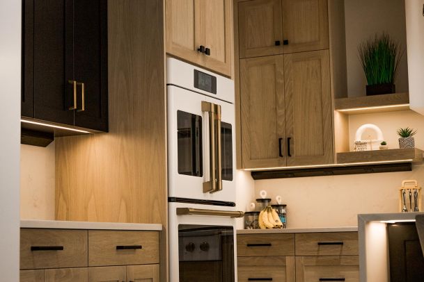 Kitchen with modern cabinetry, a built-in oven, and warm lighting.