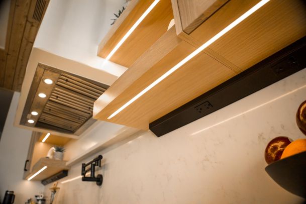 Under-cabinet lighting illuminating the kitchen counter and backsplash. 