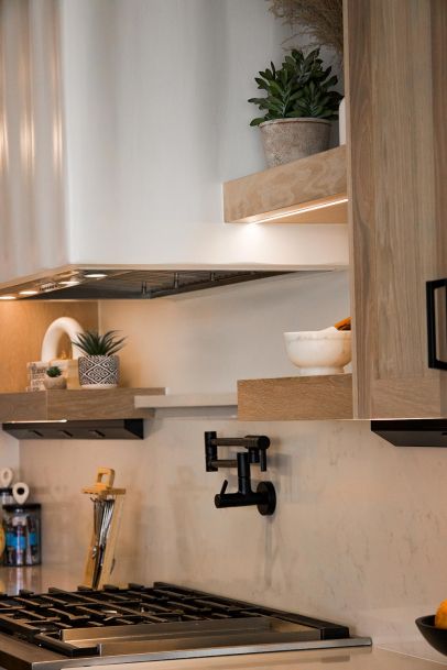 Kitchen shelves with integrated lighting highlighting decorative plants and items. 