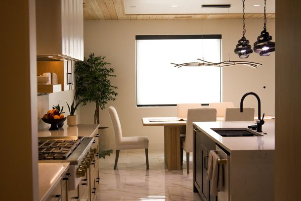 View of the kitchen and dining area with ample natural and artificial lighting. 