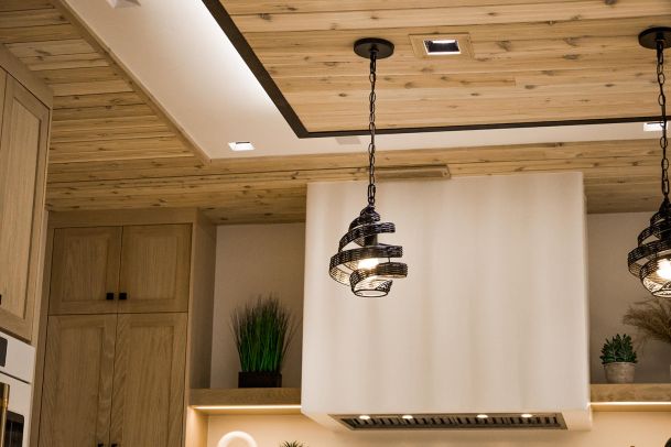 Kitchen ceiling with wooden paneling, recessed lighting, and two unique black pendant lights.